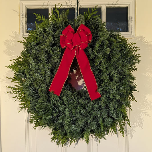 Christmas wreath with a red bow on a door
